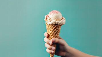 Hand holding waffle cone with tasty vanilla ice cream on color background. . photo