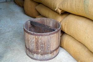 Thai Wooden bucket are used for measuring. Placed on a sack of rice. The bucket unit is a unit of measurement in Thailand in ancient times, with 1 bucket equal to 20 kilograms. photo