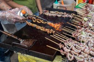 close up of delicious satay grilled squid, for sale in street food photo