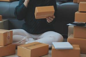 Entrepreneurs Small Business SME Independent men work at home Use smartphones and laptops for commercial checking, online marketing, packing boxes, SME sellers, concept, e-commerce team, online sales photo