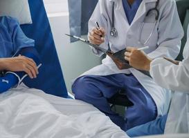 Man with broken arm in cast lying on bed in hospital. The emergency center treatment is plaster and hangs with sling for a further cure in an orthopedic clinic. Patient pain from accident injury. photo