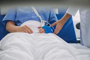 Man with broken arm in cast lying on bed in hospital. The emergency center treatment is plaster and hangs with sling for a further cure in an orthopedic clinic. Patient pain from accident injury. photo