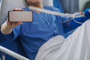 Man with broken arm in cast lying on bed in hospital. The emergency center treatment is plaster and hangs with sling for a further cure in an orthopedic clinic. Patient pain from accident injury. photo