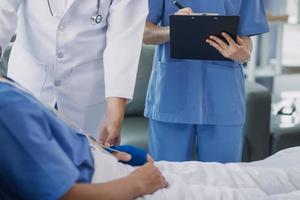 Man with broken arm in cast lying on bed in hospital. The emergency center treatment is plaster and hangs with sling for a further cure in an orthopedic clinic. Patient pain from accident injury. photo