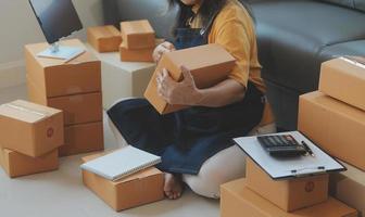 Entrepreneurs Small Business SME Independent men work at home Use smartphones and laptops for commercial checking, online marketing, packing boxes, SME sellers, concept, e-commerce team, online sales photo