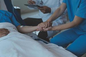 Women Asian doctors hold the patient hand and encourage and provide medical advice While checking the patient health in bed. Concept of Care and compassion, antenatal care, Threatened abortion photo