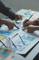 Close up ux developer and ui designer brainstorming about mobile app interface wireframe design on table with customer breif and color code at modern office.Creative digital development agency photo