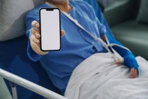 Man with broken arm in cast lying on bed in hospital. The emergency center treatment is plaster and hangs with sling for a further cure in an orthopedic clinic. Patient pain from accident injury. photo