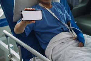 Man with broken arm in cast lying on bed in hospital. The emergency center treatment is plaster and hangs with sling for a further cure in an orthopedic clinic. Patient pain from accident injury. photo