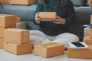 Entrepreneurs Small Business SME Independent men work at home Use smartphones and laptops for commercial checking, online marketing, packing boxes, SME sellers, concept, e-commerce team, online sales photo