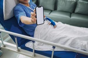 Man with broken arm in cast lying on bed in hospital. The emergency center treatment is plaster and hangs with sling for a further cure in an orthopedic clinic. Patient pain from accident injury. photo