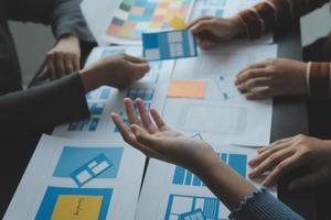 Close up ux developer and ui designer brainstorming about mobile app interface wireframe design on table with customer breif and color code at modern office.Creative digital development agency photo