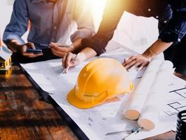 Two business man construction site engineer. Engineering objects on workplace with partners interacting on background photo