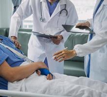 Man with broken arm in cast lying on bed in hospital. The emergency center treatment is plaster and hangs with sling for a further cure in an orthopedic clinic. Patient pain from accident injury. photo