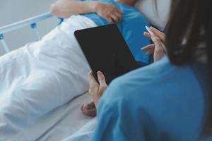 Women Asian doctors hold the patient hand and encourage and provide medical advice While checking the patient health in bed. Concept of Care and compassion, antenatal care, Threatened abortion photo