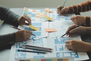 Close up ux developer and ui designer brainstorming about mobile app interface wireframe design on table with customer breif and color code at modern office.Creative digital development agency photo