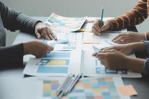 Close up ux developer and ui designer brainstorming about mobile app interface wireframe design on table with customer breif and color code at modern office.Creative digital development agency photo