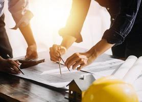 Two business man construction site engineer. Engineering objects on workplace with partners interacting on background photo