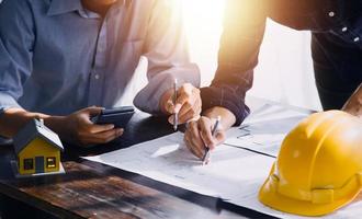 Two business man construction site engineer. Engineering objects on workplace with partners interacting on background photo