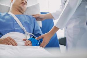 Man with broken arm in cast lying on bed in hospital. The emergency center treatment is plaster and hangs with sling for a further cure in an orthopedic clinic. Patient pain from accident injury. photo