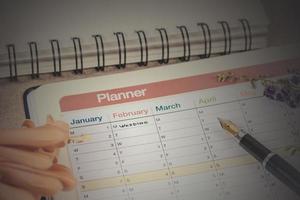 word wedding on calendar with sweet flowers and pen ,love concept. photo