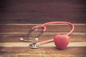 still life red heart and stethoscope on wood photo