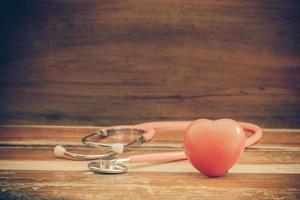 still life red heart and stethoscope on wood photo