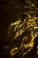 Golden texture. Wave of gold. Thin film. photo