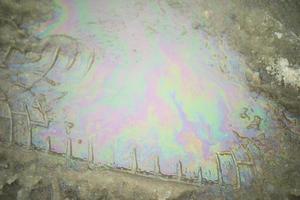 Gasoline on road. Fuel stain in puddle. Waste from transport. photo