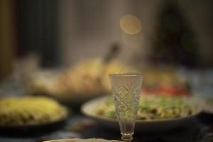 Feast in Russia. Glass of vodka on table. Festive table with food. photo