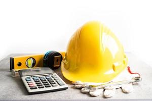 Architectural house plan project blueprint and yellow helmet with calculator, engineer construction tools. photo