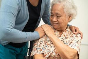 Caregiver help Asian elderly woman patient with love, care, encourage and empathy at nursing hospital, healthy strong medical concept. photo