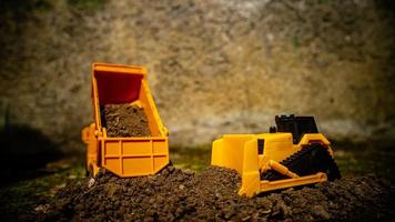 South Minahasa, Indonesia  January 2023, a yellow dump truck toy transporting sand photo