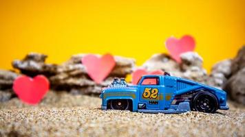 Minahasa, Indonesia  December 2022, toy car with gradient orange background and a heart photo