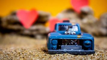 Minahasa, Indonesia  December 2022, toy car with gradient orange background and a heart photo