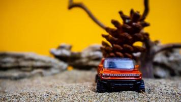 toy car hauling pinecones on an orange background photo