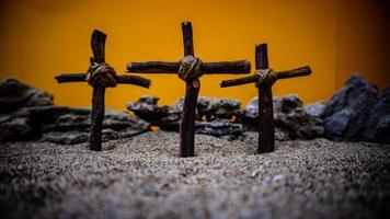 crosses stuck in the sand on an orange background photo