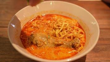 khao soi, nouilles thaïlandaises khao soi, poulet au curry avec assaisonnement sur parquet, concept de cuisine du nord de la thaï. nouilles au curry du nord de la thaïlande avec du poulet video