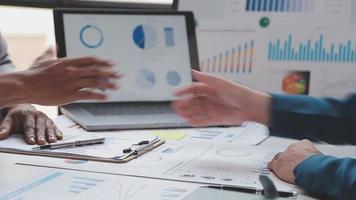 Financial analysts analyze business financial reports on a digital tablet planning investment project during a discussion at a meeting of corporate showing the results of their successful teamwork. video