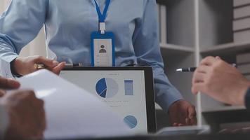 Financial analysts analyze business financial reports on a digital tablet planning investment project during a discussion at a meeting of corporate showing the results of their successful teamwork. video