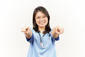 sonriente y señalando a tú, querer usted gesto de asiático joven médico aislado en blanco antecedentes foto