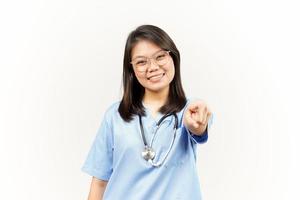 sonriente y señalando a tú, querer usted gesto de asiático joven médico aislado en blanco antecedentes foto