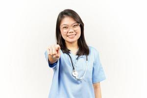 sonriente y señalando a tú, querer usted gesto de asiático joven médico aislado en blanco antecedentes foto