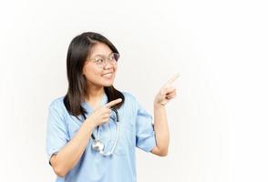 Showing Product and Pointing Side Of Asian Young Doctor Isolated On White Background photo