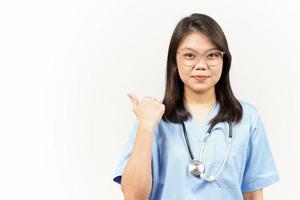 demostración y señalando producto con pulgar de asiático joven médico aislado en blanco antecedentes foto