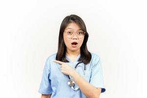 Showing Product and Pointing Side Of Asian Young Doctor Isolated On White Background photo