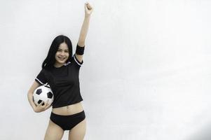 joven y hermosa mujer asiática viste a un jugador de fútbol animando el deporte, las hinchas femeninas animan el juego de fútbol foto