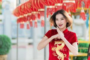 Portrait beautiful asian woman in Cheongsam dress,Thailand people,Happy Chinese new year concept,Happy asian lady in chinese traditional dress holding a red envelope photo