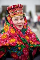 Russian woman in a national headdress and a painted scarf. Vertical portrait of a dewy Slav. photo