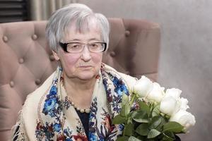 público comida habitación. mayor mujer con un ramo de flores de rosas. foto